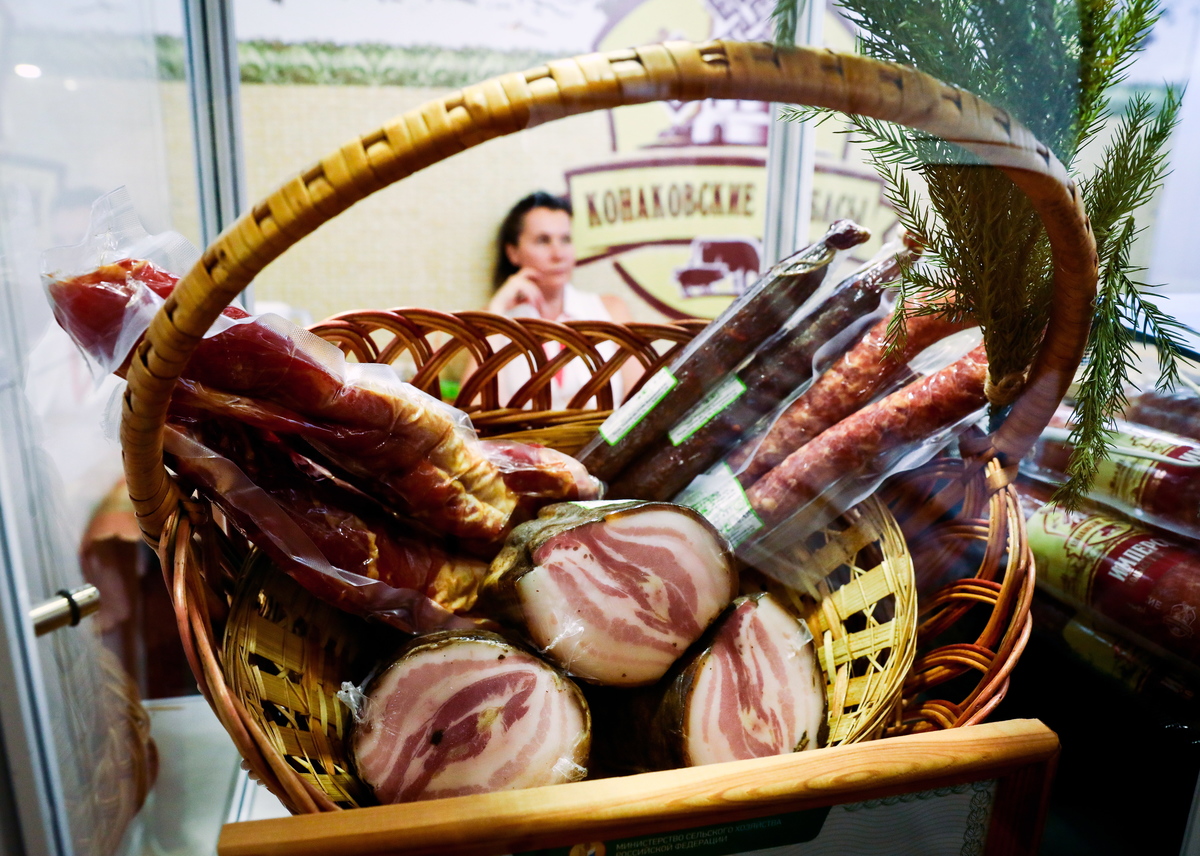 Processed meats sit in a woven basket at a butcher shop.