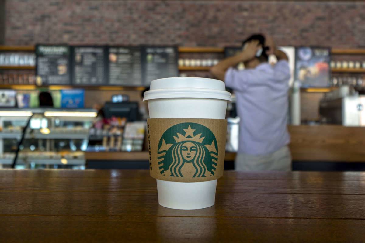 A to-go Starbucks cup is pictured on a table.
