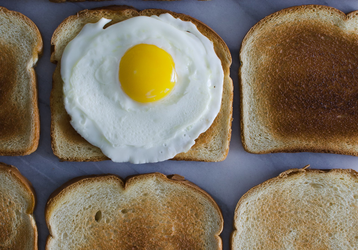 Toast is laid out, and an egg is on one.